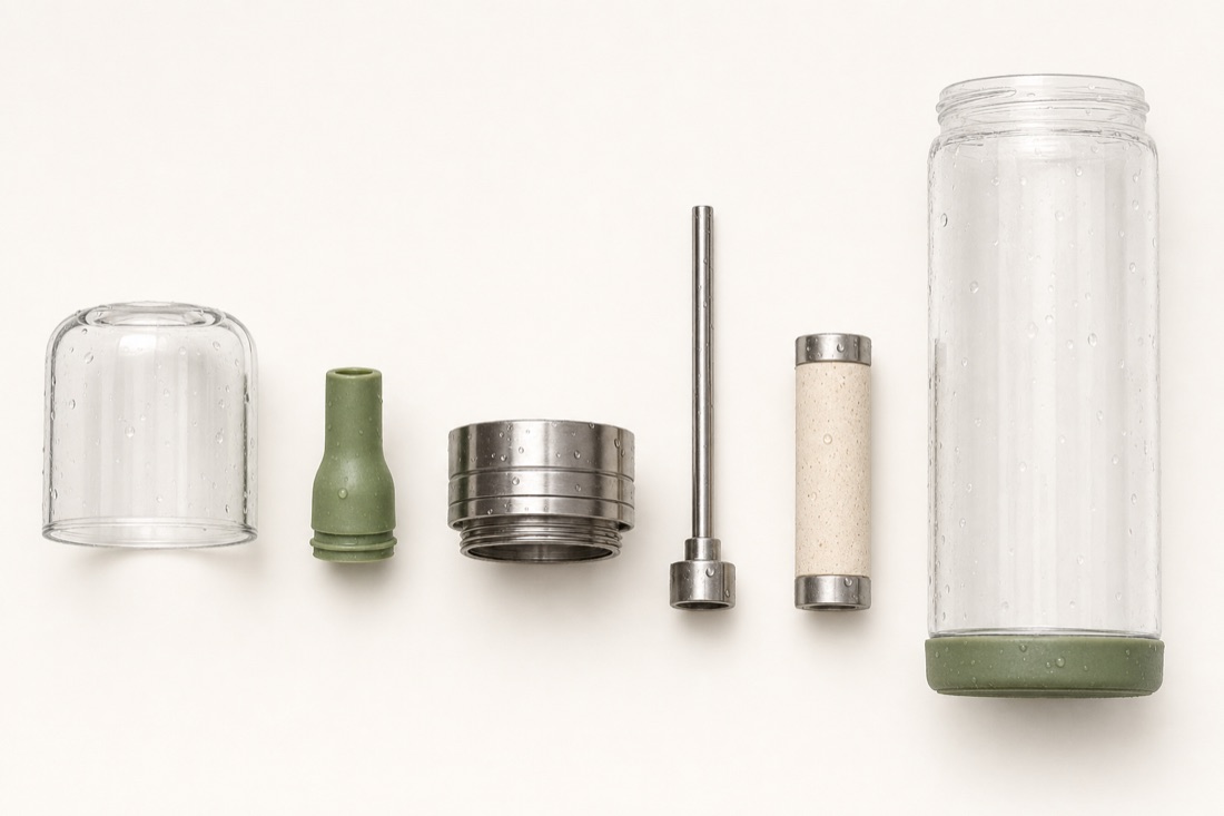 The Sift bottle disassembled into six parts — glass body, glass cap, steel lid, sage silicone mouthpiece, rigid straw, and filter cartridge